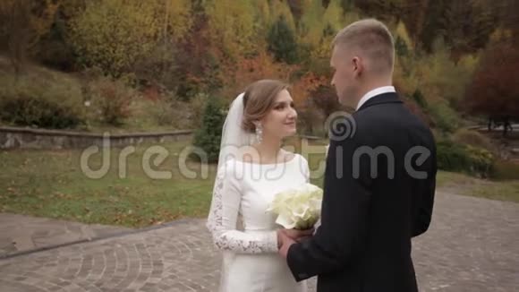 英俊的新郎和迷人的新娘在公园举行婚礼后一起度过视频的预览图