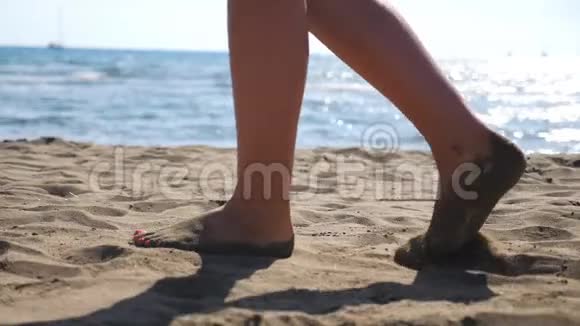 女性的脚在沙滩上行走背景是海景年轻女子踏着海的腿视频的预览图