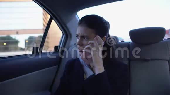 女商人坐在后座上打电话工作压力大交通视频的预览图