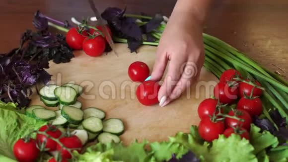 特写镜头中的女人在木制砧板上切樱桃西红柿4公里视频的预览图