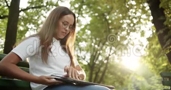 女人开始在户外的笔记本电脑上工作视频的预览图