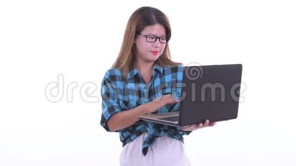 快乐的年轻亚洲时髦女人在用笔记本电脑思考视频的预览图
