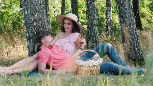 野餐时间快乐的年轻夫妇玩得很开心他开了个玩笑公园的户外活动视频的预览图