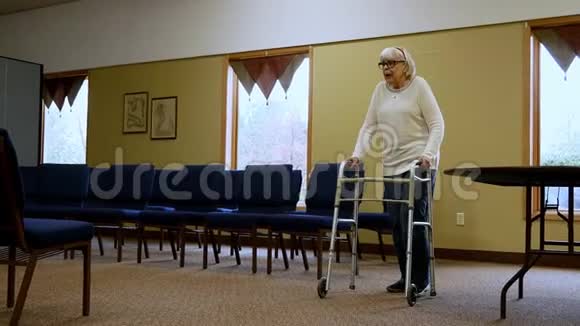 老年妇女在步行者的帮助下在地毯上向左走视频的预览图