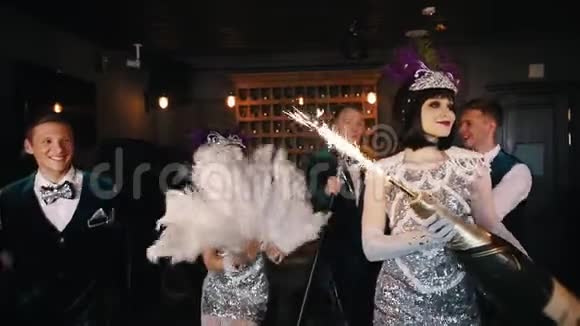 复古主题派对年轻人玩得开心一个女人拿着一瓶巨大的香槟上面放着烟火视频的预览图