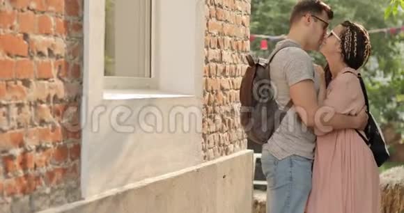 在家附近的街道上亲吻和拥抱年轻夫妇视频的预览图