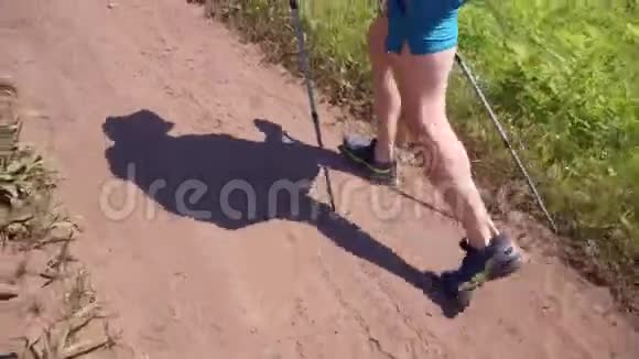 在这个框架里一个人的腿在一条泥泞的道路上徒步行走视频的预览图