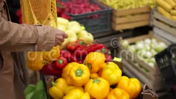 无法辨认的女人在超市买红辣椒顾客把蔬菜放在可重复使用的袋子里环保视频的预览图