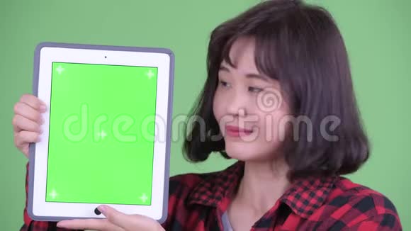 快乐的亚洲时髦女人展示数码平板电脑的脸视频的预览图