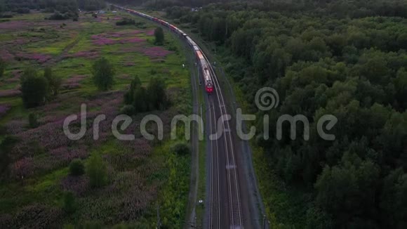 货运列车穿越秋林空中射击无人驾驶飞机的4K镜头视频的预览图