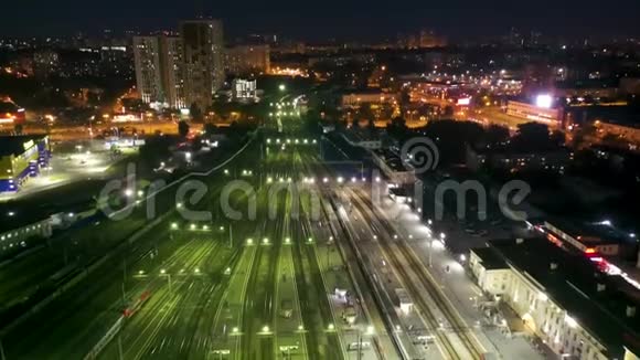 在俄罗斯叶卡捷琳堡火车站的路上飞过人和火车在夜间照明路径视频的预览图