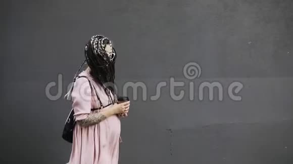 快乐的年轻孕妇嬉皮士带着咖啡走在城市的街上视频的预览图