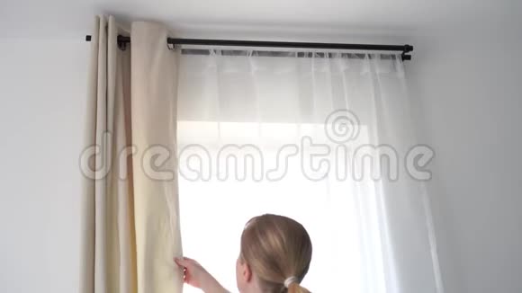 家庭内部一个金发碧眼的女人在卧室里拉上窗帘视频的预览图
