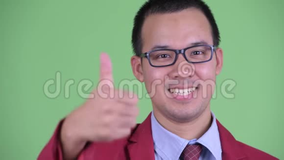 戴着眼镜竖起大拇指的快乐亚洲商人的脸视频的预览图