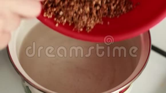 荞麦在厨房里煮沸腾的水蒸气午餐做饭把谷物倒入锅中视频的预览图
