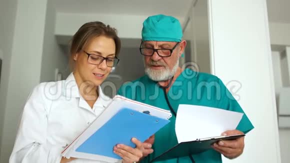 门诊工作人员上班期间两名医生在为摄影师摆姿势开会一位留着胡子的灰发男子视频的预览图