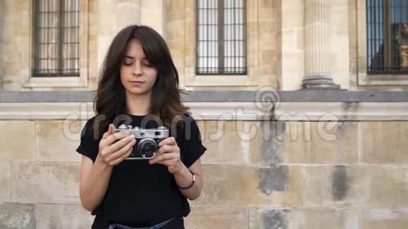 漂亮的女人在背景上拍一部电影相机巴黎的旧建筑背景视频的预览图