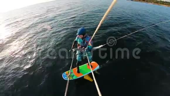 一个穿泳装的人在河边玩风筝视频的预览图