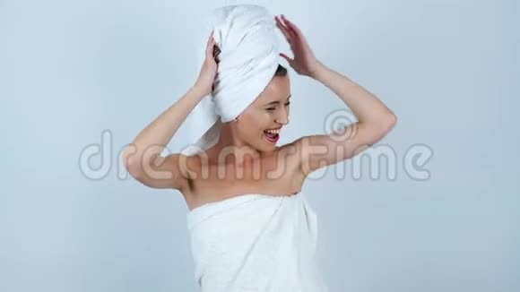 年轻的美女头上戴着白毛巾身体上戴着白毛巾两臂挽着孤零零的白毛巾欢快地跳舞视频的预览图