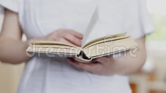 女人手翻书页合上一本书视频的预览图