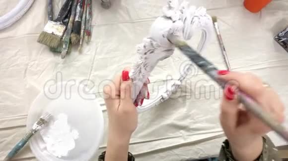 女人用白色油漆画相框视频的预览图