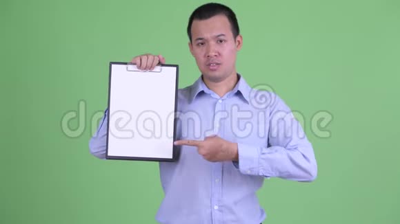 穿着整齐的亚洲商人展示剪贴板竖起大拇指视频的预览图