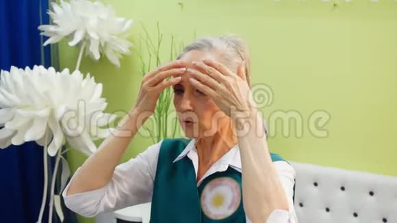 老年妇女正在做抗衰老的面部按摩以对抗皱纹视频的预览图