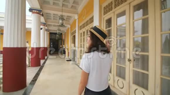 旅游妇女在夏季旅行时漫步在柱廊古建筑上视频的预览图