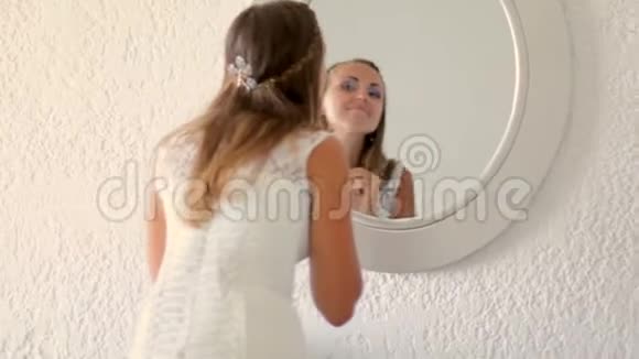 穿着白色连衣裙的女孩在镜子前化妆整齐视频的预览图