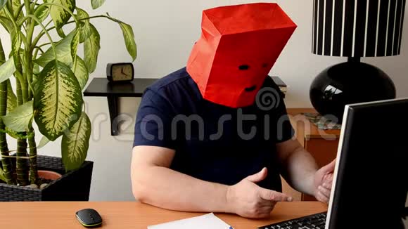 一个人把红色的纸袋从他的头上移开有黑色的巴拉巴拉视频的预览图