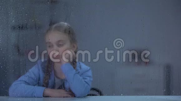 护士把水和药丸带到生病的小女孩面前透过雨窗视频的预览图