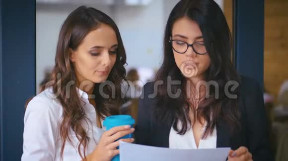 两位年轻的女商人自信的经理在办公室背景下讨论文件女同事分享想法视频的预览图