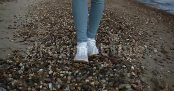 穿鞋的女性脚在海边的小石头上行走视频的预览图