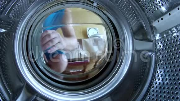年轻人把东西放在洗衣机里动作镜头特写视频的预览图