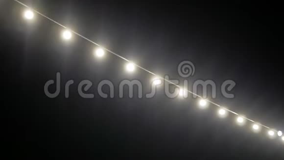 一串明亮的电灯白色明亮的灯光映衬着夜空视频的预览图