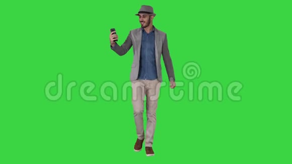 有魅力的男人穿着休闲服装帽子时髦的风格记录Vlog或视频呼叫绿色屏幕Chroma键视频的预览图