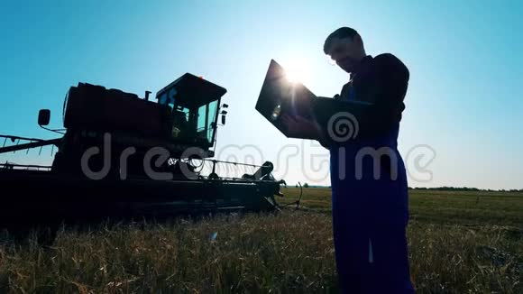 农学家站在一个田野里用笔记本电脑工作视频的预览图