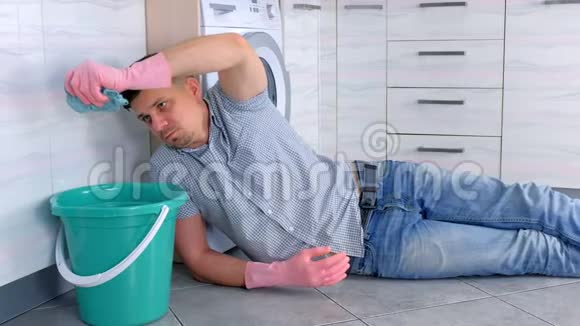 穿着橡胶手套的累人把抹布压在放在厨房地板上的水桶上视频的预览图
