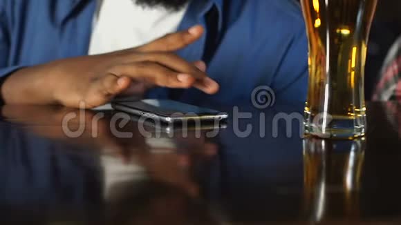 非裔美国人在酒吧休息喝啤酒打电话聊天视频的预览图