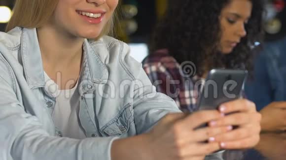 快乐的女人在智能手机上和男朋友在酒吧聊天恋爱视频的预览图