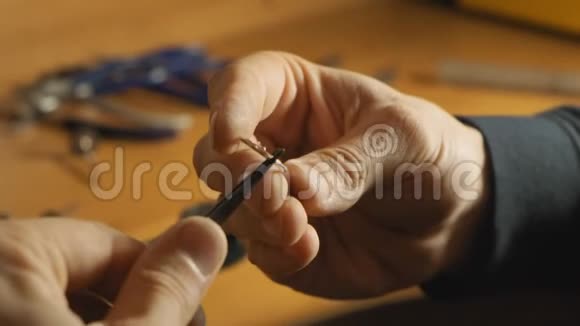 金匠用镊子握着金属戒指用珠宝炉慢慢加热视频的预览图