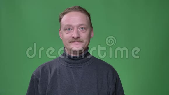 中年白种人留着胡子的肖像在绿色背景下的镜头中表现出极度的兴奋视频的预览图