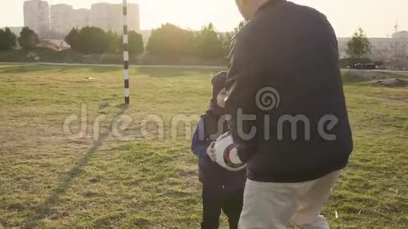 爸爸把他的儿子放在肩上帮他把球扔进足球大门视频的预览图