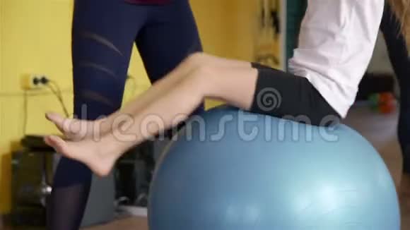 训练员协助女子健身球运动视频的预览图