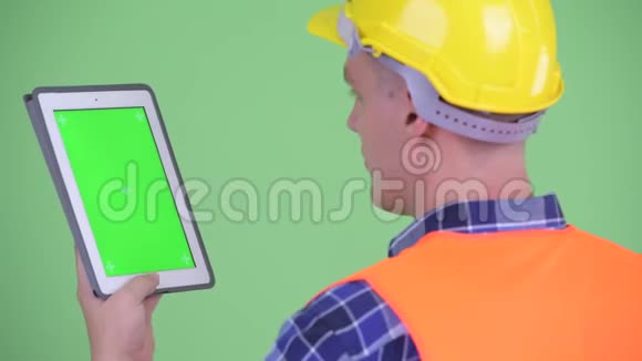 青年建筑工人使用数码平板电脑的近距离后视镜视频的预览图