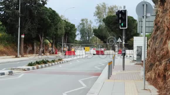 前面有路障正在施工的道路被有红绿灯和白色红色栅栏的路障堵塞建设概念视频的预览图