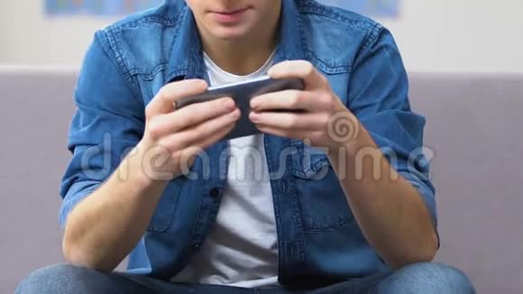 青少年在智能手机上玩快节奏的电子游戏闲暇时间视频的预览图