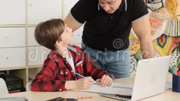 父亲在笔记本屏幕上向儿子展示了如何为这项任务找到答案视频的预览图