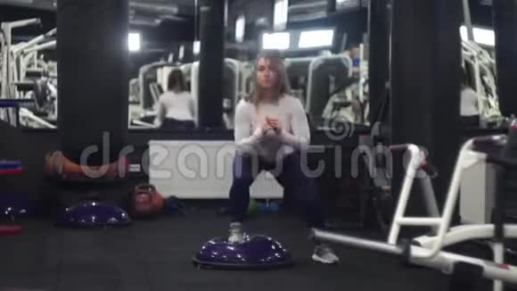女子跳博苏在健身房做有氧运动她独自一人专注于取得成果视频的预览图
