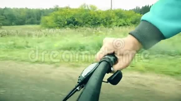 波夫自行车射击雨天在森林道路上骑自行车时人的手握着自行车和变形器视频的预览图